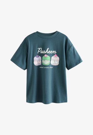 Tirkizna bomba iz bombaža z grafiko treh ljubkih likov sladic, besedilom "Pusheen" in "sladko vsak dan". Kratki rokavi in sproščen kroj.