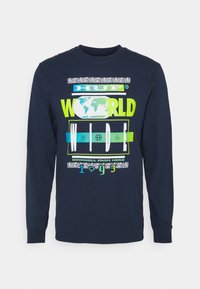 Mörkblå långärmad skjorta med ljus grafisk text "HUF World Wide" och en jordglobillustration, accentuerad med "Downhill from here 1993."