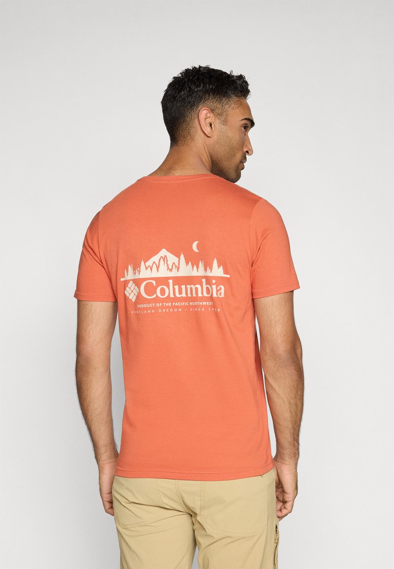 Kurzärmliges T-Shirt mit Rundhalsausschnitt in Koralle, mit einem weißen Grafikmotiv von Bergen und Bäumen, das den Text "Columbia" sowie ein Mondmotiv auf der Rückseite zeigt.
