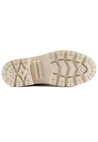 Semelle de chaussure en caoutchouc beige avec des motifs de semelle incluant des formes de diamant, des rainures et des trous de ventilation circulaires.