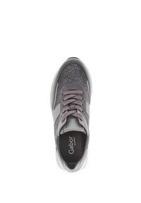 Grijze sneaker met glinsterende stof, grijze veters en witte zool, gemerkt "Gabor Comfort" op de binnenzool, van bovenaf bekeken op een witte achtergrond.