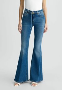 Jeans a zampa d'elefante blu con vita alta, realizzati in denim classico. Presentano tasche frontali, passanti per la cintura e un leggero effetto scolorito.