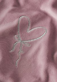 Rosa Stoff mit einem silbernen, gestickten Herzballon-Design und einer Schleife, der eine weiche Textur und einen glatten Glanz zeigt.