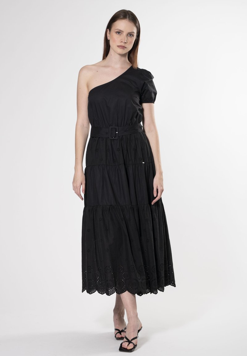 Vestido negro de un solo hombro con manga abullonada, diseño en capas y cinturón en la cintura. Presenta detalles bordados y un dobladillo con forma de concha.