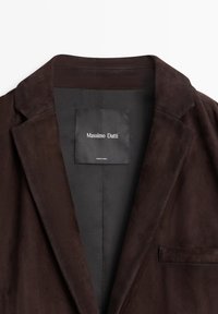 Brown suede blazer featuring a notched lapel, single chest pocket, and a label with "Massimo Dutti" inside. Smooth texture and tailored design.