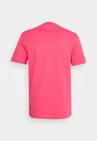 T-shirt à manches courtes de couleur rose vif, fabriqué en coton doux. Il présente un col rond et un dos uni sans impressions ni embellissements.