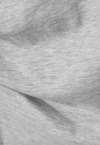 Material textil gri deschis cu o suprafață moale, ușor texturată, prezentând nuanțe variate și modele subtile rezultate din cute și pliuri.