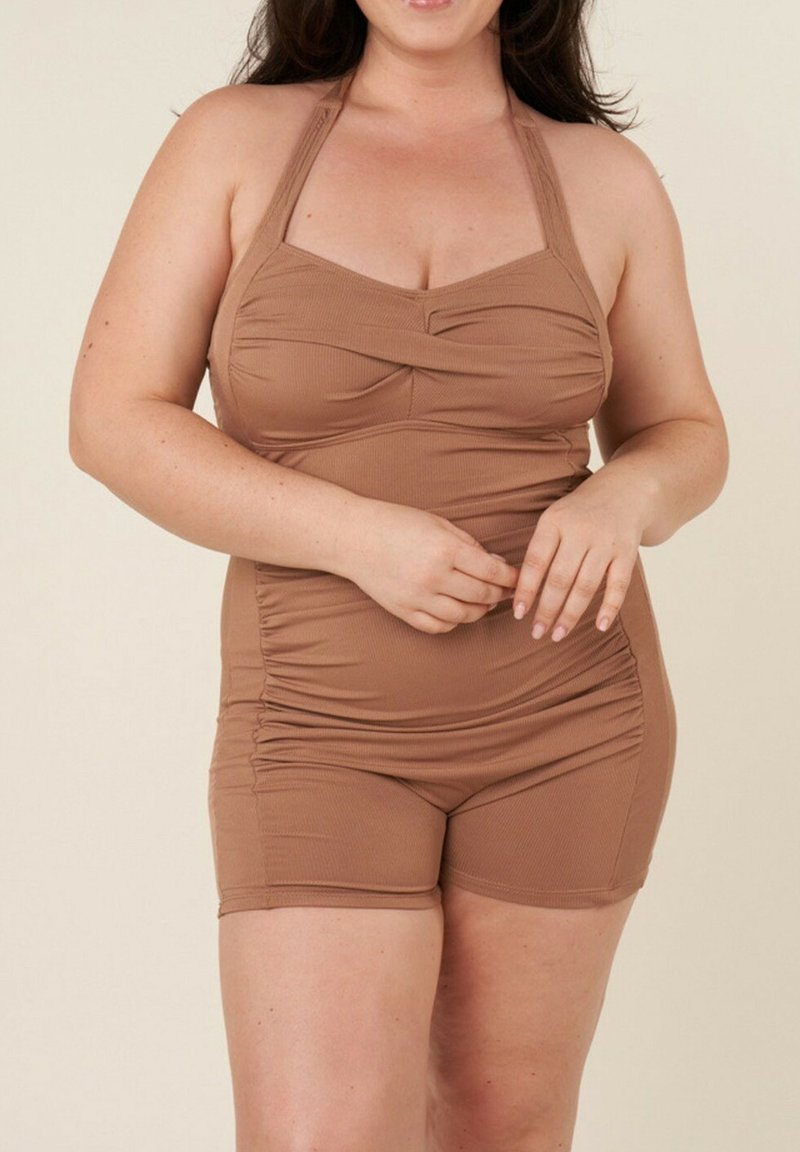 Maillot de bain marron à col halter côtelé avec des détails froncés et un bas type short, offrant une coupe ajustée et une texture lisse.