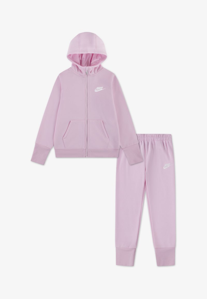 Roza majica z zadrgo Nike in hlače, izdelani iz mehke tkanine. Majica ima sprednjo zadrgo, kengurujevske žepe in bel logotip.