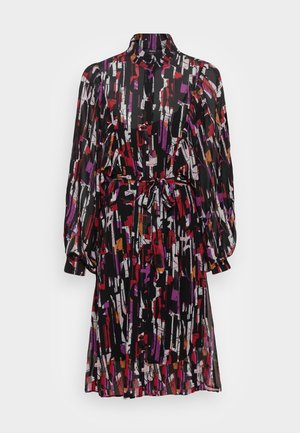 Sukienka z długimi rękawami z lekkiego materiału, z czarnym tłem i abstrakcyjnymi wzorami w kolorach czerwonym, fioletowym i pomarańczowym. Zapięcie na guziki z przodu oraz pasek w talii.