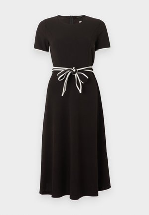 Μαύρο midi φόρεμα με κοντά μανίκια, στρογγυλή λαιμόκοψη και λευκή ζώνη δεμένη σε φιόγκο στη μέση.