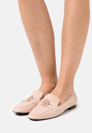 Zarte Wildleder-Lederschuhe mit flacher Sohle, abgerundetem Zehenbereich und einem dekorativen metallischen Schnallen-Detail auf der Vorderseite.