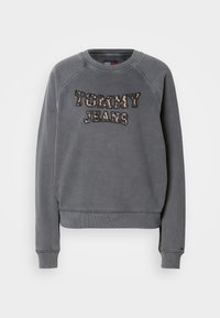 Felpa grigia con colletto rotondo, maniche raglan e ricamo "TOMMY JEANS" in un design a stampa leopardata. Materiale morbido con polsini a coste.