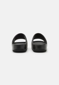 Sandale negre cu talpă joasă, dotate cu două curele late, un finisaj neted și o talpă cu striații pentru aderență. Design minimalist și spate deschis pentru ventilație.