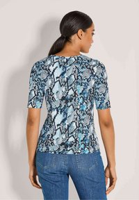 Kurzarmoberteil mit einem blauen und schwarzen Schlangendruckmuster, aus glattem Stoff, mit rundem Ausschnitt und figurbetonter Silhouette.