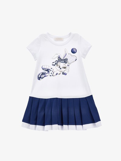 Vestito bianco a maniche corte con un coniglio blu dei cartoni animati che gioca a tennis. La gonna è di un blu navy con pieghe e un bordo bianco all'orlo.