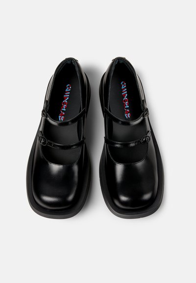 Scarpe in pelle nera con punta arrotondata, design a doppia cinghia e superficie liscia. L'interno presenta un logo colorato in blu e rosso.