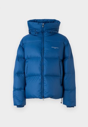 Chaqueta acolchada azul con alto cuello, cierre de cremallera y detalles con cordón. Presenta secciones acolchadas y una marca mínima.