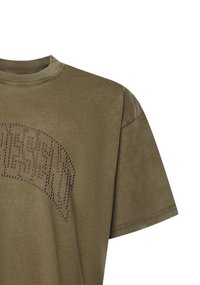 Camiseta de algodón verde oliva con mangas cortas, que presenta un escote redondo y un patrón de texto decorativo hecho de pequeñas tachuelas en la parte delantera.