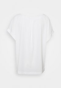 Blouse blanche à manches courtes, coupe ample avec un détail plissé au dos, présentée sur un fond uni.