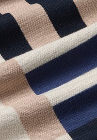 Gestreepte textiel met roze, crème en marineblauwe kleuren met een zachte, gestructureerde oppervlakte. Het patroon heeft brede, afwisselende banen.