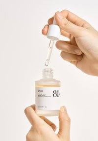 Bottiglia di vetro trasparente con un tappo contagocce bianco, contenente un liquido giallo chiaro. L'etichetta mostra il nome del prodotto e la concentrazione, formato da 30 ml.