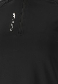 Zwarte sporttop met een ritskraag en het 'ELITE LAB' logo in zilver aan de rechterzijde. Glad, rekbaar materiaalmateriaal.