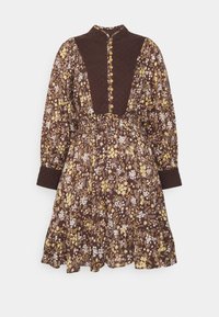 Robe florale marron à manches longues, boutonnée à l'avant, avec une taille élastique. Motif de fleurs jaunes et blanches sur un tissu marron foncé.