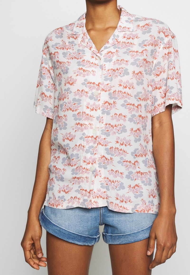 Short-sleeve, button-front shirt made of lightweight fabric with a floral pattern in light gray, lavender, and coral. Timeless collar design.