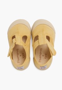 Gele canvas schoenen met uitsparingen aan de zijkanten, merknamen aan de binnenkant en een stevige rubberen zool. Het ontwerp heeft een klittenbandsluiting voor bevestiging.