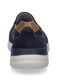Navy-Flauschschuhe mit einem sandfarbenen Lederakzent an der Ferse, runder Form, gepolsterter weißer Sohle und atmungsaktiver Fütterung.