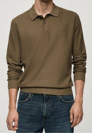 Polo à manches longues en tissu vert olive texturé, avec un col classique et une patte de boutonnage à trois boutons, associé à un jean en denim bleu foncé.