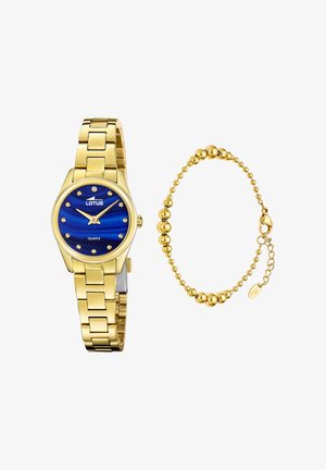 Reloj de cuarzo con tono dorado, esfera azul y marcadores de hora similares a diamantes, acompañado de una pulsera de cuentas doradas con cierre y cadena ajustable.