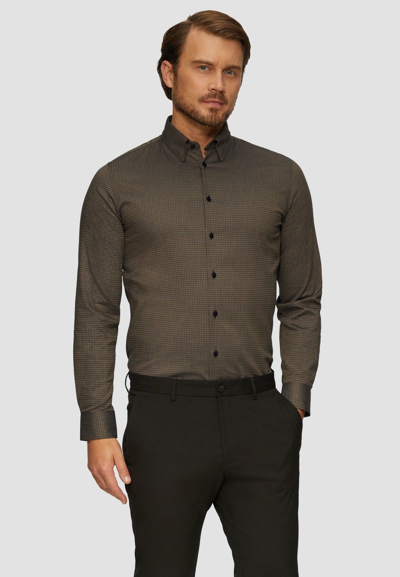 Herren Langarmhemd in Dunkelgrün mit kleinem Karomuster, Button-Down-Kragen und schwarzen Knöpfen. Kombiniert mit dunklen Hosen.