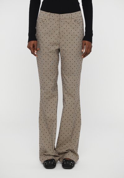 Lichtbruine gestreepte broek met een geruit ontwerp en kleurrijke stippen. Heeft een uitlopend been en zijzakken. Gemaakt van geweven stof.