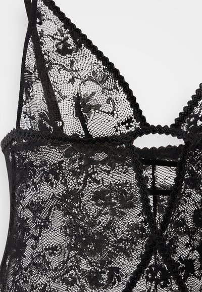 Fekete csipkés body virágmintákkal, hullámos széllel és kulcslyuk részlettel, átfedő pántokkal. Finom és áttetsző anyag.