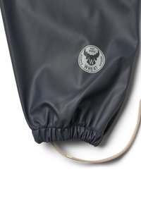 Donkerblauwe waterdichte stof met een geraapte zoom, featuring een ronde logo patch in grijs met een moose afbeelding en de tekst "WHEAT DESIGN". Inclusief beige trekkoord.
