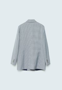 Jasnoniebieska marynarka w białą kratę z usztywnionym kołnierzem, długimi rękawami i trzema srebrnymi guzikami na mankietach. Widok z tyłu.