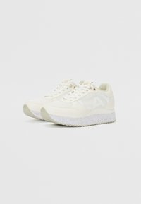 Zapatillas deportivas blancas con un upper de material mixto, que presenta secciones de malla y lisas, una suela texturizada y un diseño de plataforma ligera.