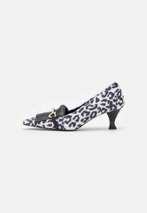 Buty na niskim obcasie typu kitten heel z czarno-białym wzorem w cętki lamparta, czarną frędzlą oraz małą złotą klamrą po boku.