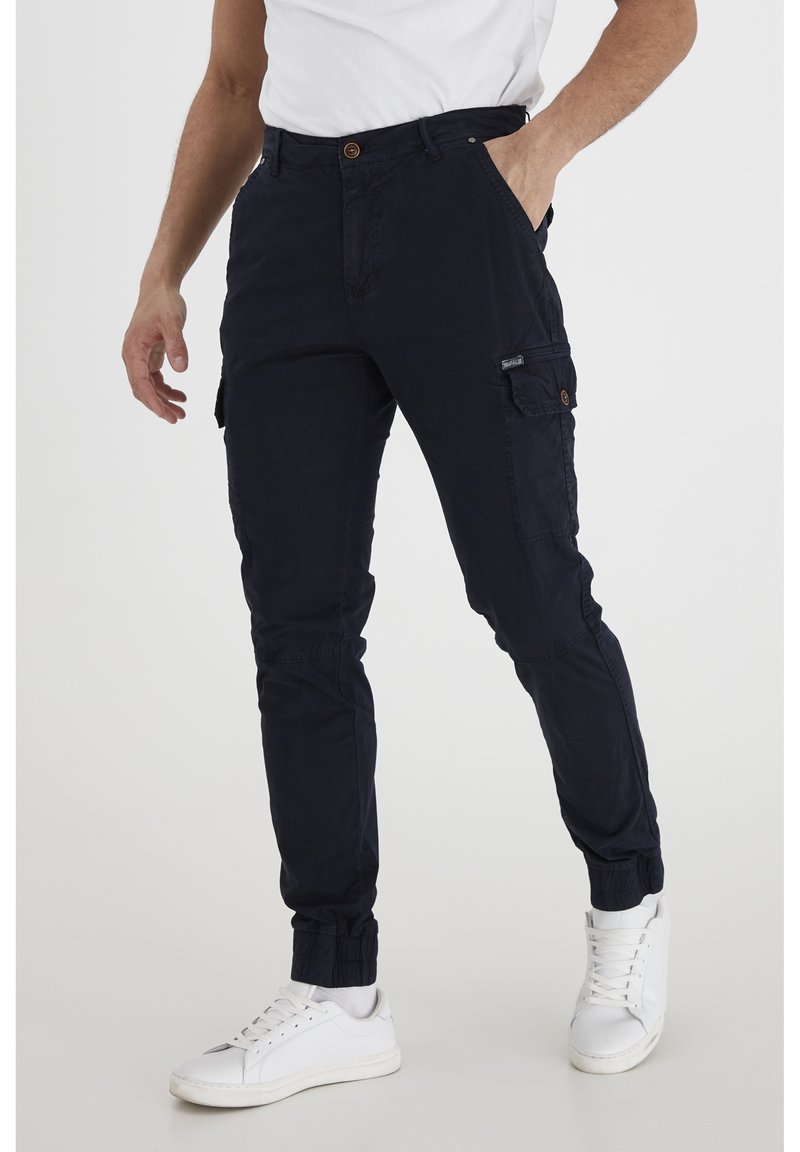 Pantalones de cargo de marina con puños elásticos, que cuentan con bolsillos laterales y cierre de botón. Fabricados en una tela suave con una textura lisa.
