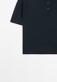 Dunkel marineblaues Poloshirt mit kurzen Ärmeln und Strickstruktur, ausgestattet mit einer dreiknöpfigen Knopfleiste und gerippten Abschlüssen an Ärmeln und Saum.