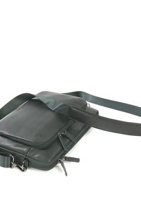 Borsa a tracolla verde in pelle con una texture liscia, un compartimento con zip e un design piatto. Presenta una tracolla regolabile e hardware in metallo.