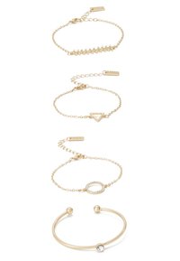 Bracelets en or de différentes conceptions : l'un avec des pierres claires, l'un avec un triangle, un autre avec un accent circulaire, et un style manchette.