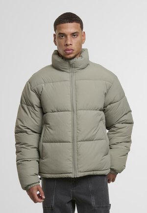 Padded jacket in light green, with a high collar and front zipper. Features elastic cuffs and a boxy shape with stitched sections.