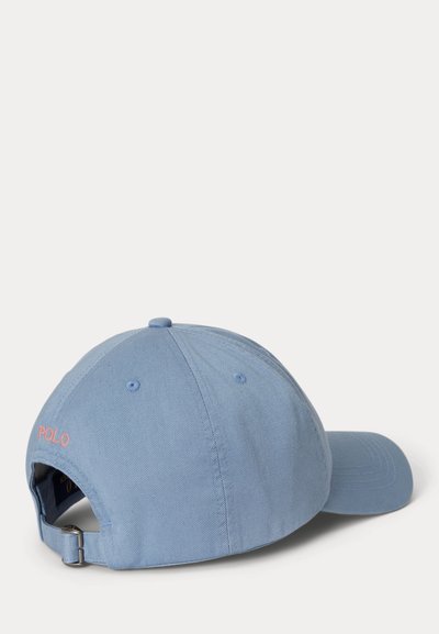 Casquette de baseball bleu clair avec boucle métallique réglable et "POLO" brodé en rose au dos, présentée sur un fond blanc uni.