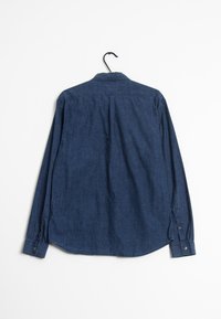 Mörkblå långärmad skjorta med krage, knappmanschetter och rundad nederkant. Tyget verkar mjukt med en något strukturerad yta.