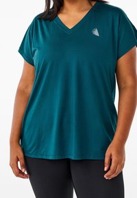 Teal v-hals t-shirt, korte ærmer, blødt stof, løs pasform, med en lille hvid grafisk detalje øverst til venstre.