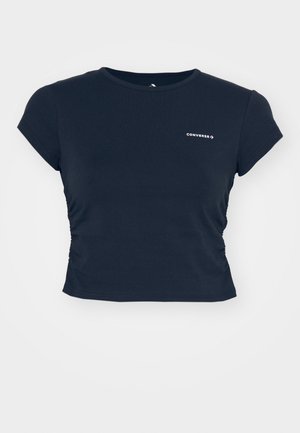 T-shirt cropped a maniche corte di colore blu navy, realizzato in cotone, con dettaglio arricciato sul lato e logo "Converse" bianco sul petto.