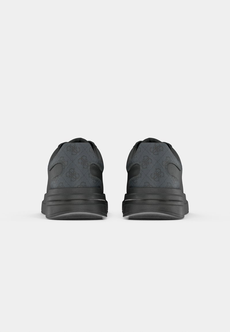 Paire de baskets noires vues de dos avec une semelle épaisse et un motif subtil sur la tige en tissu sur fond gris uni.